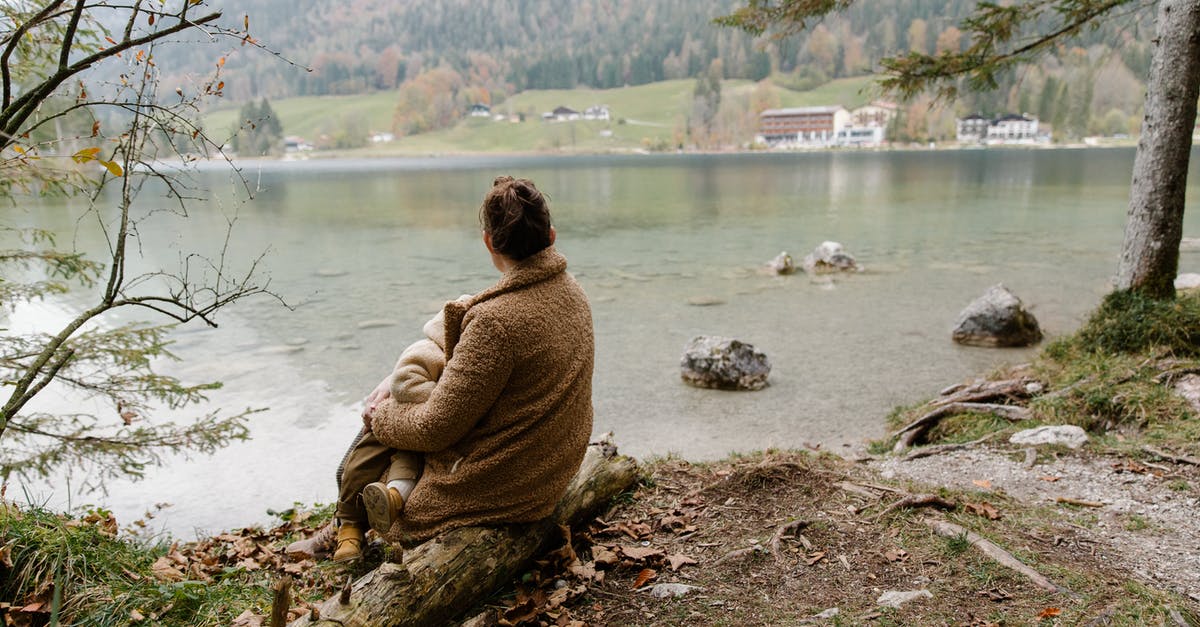 Oops left baby back ribs on warm instead of low for 7 hrs [duplicate] - Back view of unrecognizable mother in casual warm outerwear sitting with baby on hands on log near lake and admiring calm scenery in overcast weather