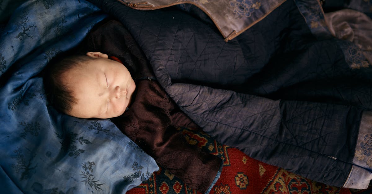 Oops left baby back ribs on warm instead of low for 7 hrs [duplicate] - Sleeping ethnic baby in traditional clothes under jacket of adult man