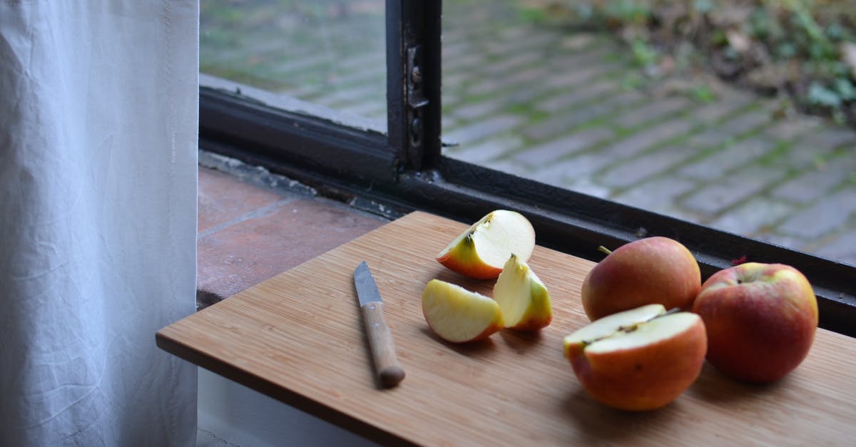 Optimal shape to cut apples for apple pie - Ripe sliced apples on cutting board with knife near window Optimal shape to cut apples for apple pie - Ripe sliced apples on cutting board with knife near window