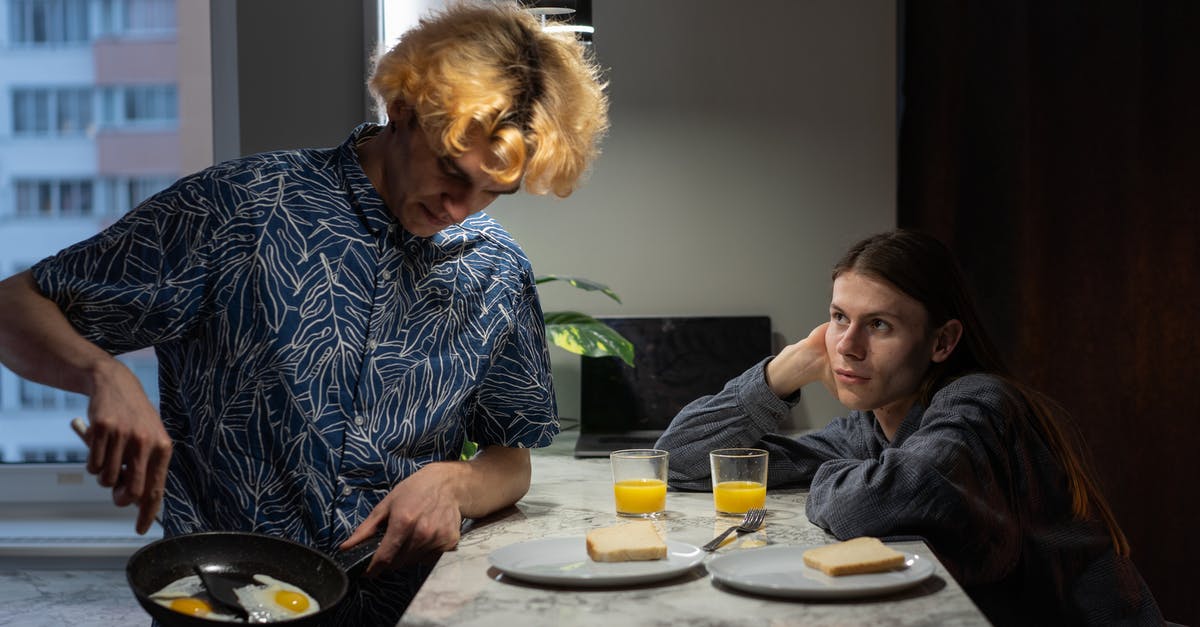 Over easy eggs sticking in copper pan - A Couple Having Breakfast Over easy eggs sticking in copper pan - A Couple Having Breakfast
