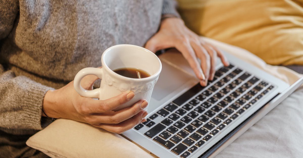 Pans with ceramic coating useful? - Crop freelancer with mug of coffee typing on laptop