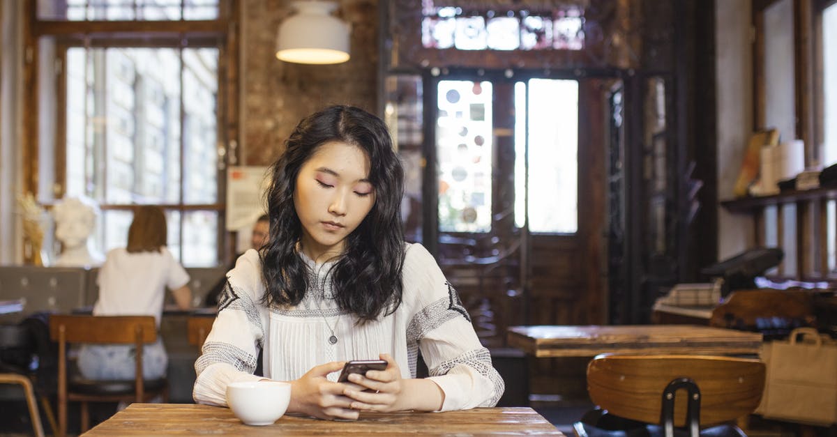 Pans with ceramic coating useful? - Woman Sitting on the Table Holding Her Cellphone