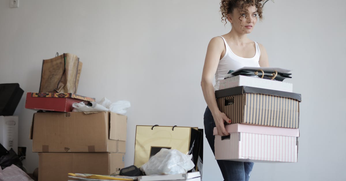 Parsley: flat-leaf or curly? - Concentrated woman carrying stack of cardboard boxes for relocation Parsley: flat-leaf or curly? - Concentrated woman carrying stack of cardboard boxes for relocation