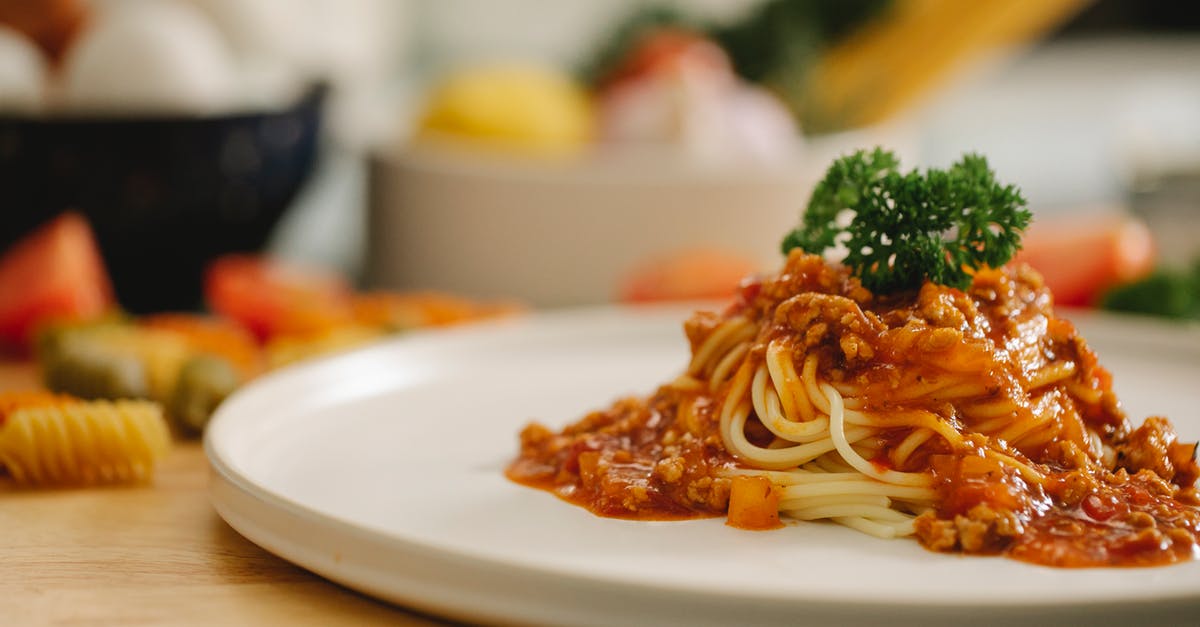 Pasta: is simmering equivalent to roiling boil? - Delicious yummy spaghetti pasta with Bolognese sauce garnished with parsley and served on table in light kitchen Pasta: is simmering equivalent to roiling boil? - Delicious yummy spaghetti pasta with Bolognese sauce garnished with parsley and served on table in light kitchen