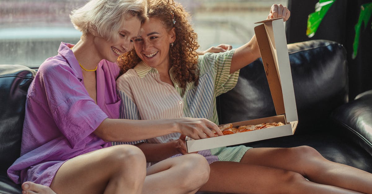 Pizza fries getting burnt - Women Sharing a Box of Pizza on a Couch Pizza fries getting burnt - Women Sharing a Box of Pizza on a Couch