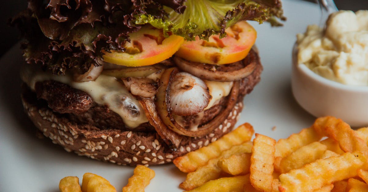 Potato Crisp making - Burger With Sliced Tomato and Lettuce on White Ceramic Plate Potato Crisp making - Burger With Sliced Tomato and Lettuce on White Ceramic Plate
