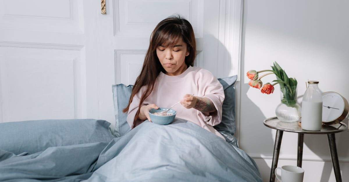 Premixed Bircher muesli (cereal) - soak overnight or ready-to-eat? - Woman eating breakfast in a bed Premixed Bircher muesli (cereal) - soak overnight or ready-to-eat? - Woman eating breakfast in a bed