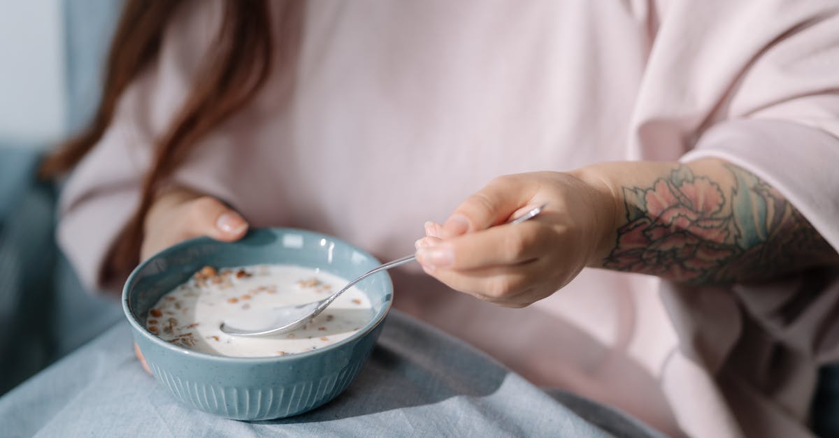 Premixed Bircher muesli (cereal) - soak overnight or ready-to-eat? - Woman eating cereal with milk Premixed Bircher muesli (cereal) - soak overnight or ready-to-eat? - Woman eating cereal with milk