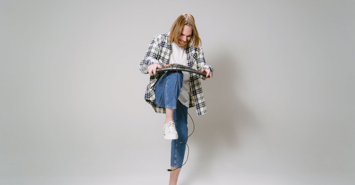 Prep before breaking down chicken - Woman in White and Black Long Sleeve Shirt and Blue Denim Jeans Standing and Holding Black Prep before breaking down chicken - Woman in White and Black Long Sleeve Shirt and Blue Denim Jeans Standing and Holding Black