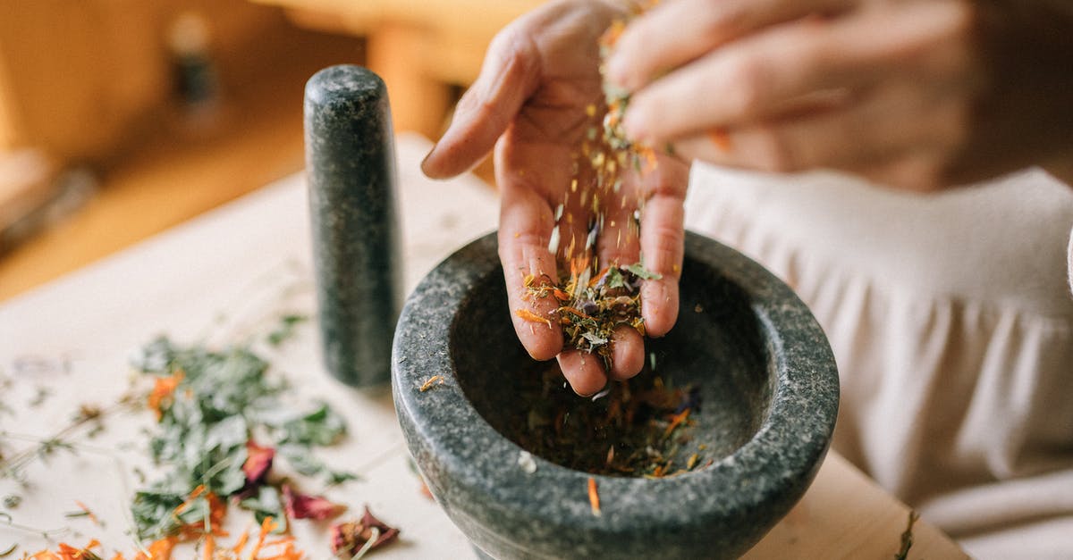 Preparation Techniques for Tilapia Filets - Women Preparing Dry Herbs in Mortar and Pestle
