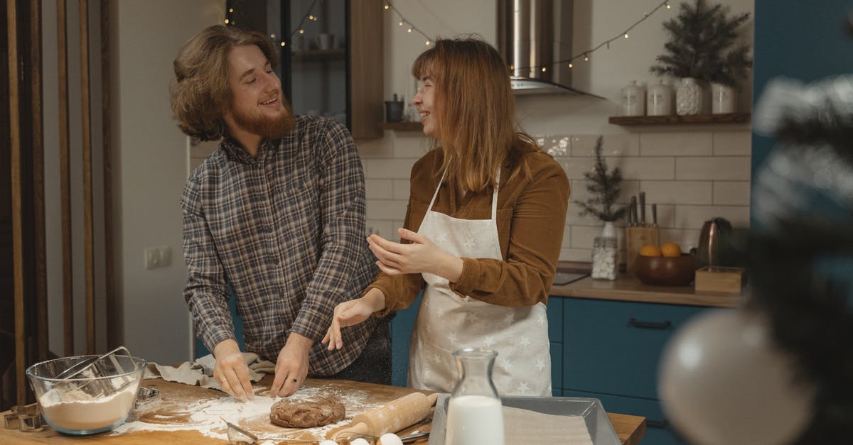 Preparing Brown Rice - Happy Couple Standing at the Table with Flour and Dough Preparing Brown Rice - Happy Couple Standing at the Table with Flour and Dough