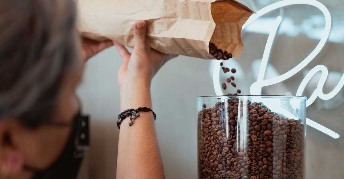 preparing lupini beans? - Photo of Barista Pouring Fresh Coffee Beans on Coffee Grinder preparing lupini beans? - Photo of Barista Pouring Fresh Coffee Beans on Coffee Grinder