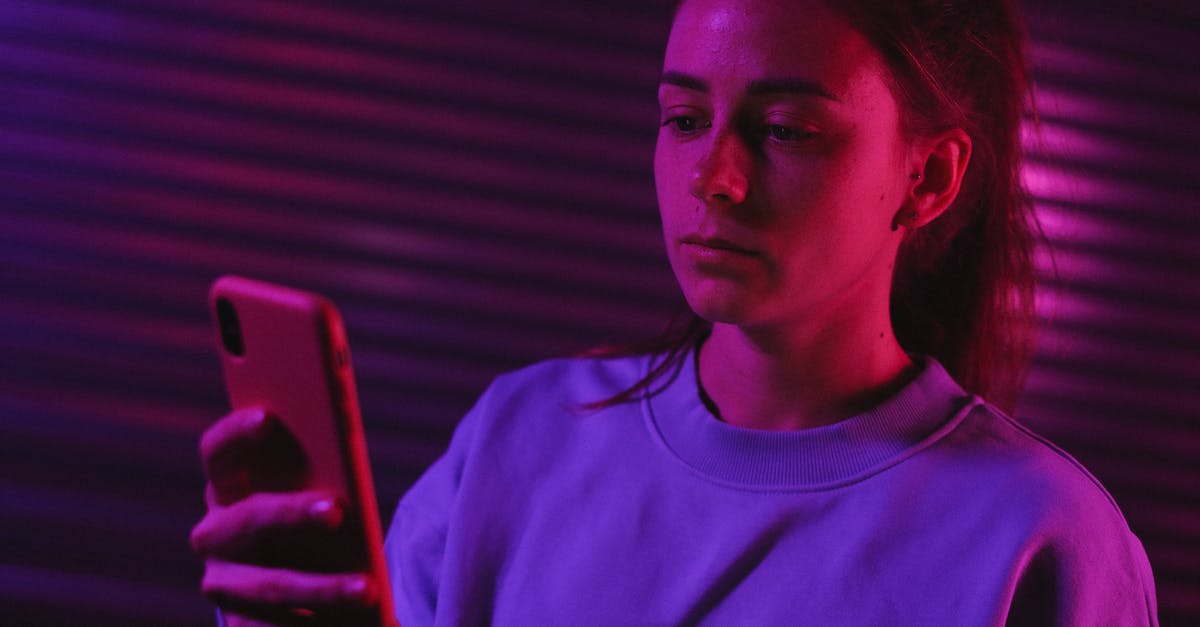 Preparing minced garlic the night before using them - Pensive female browsing smartphone in dark room with colorful lights Preparing minced garlic the night before using them - Pensive female browsing smartphone in dark room with colorful lights