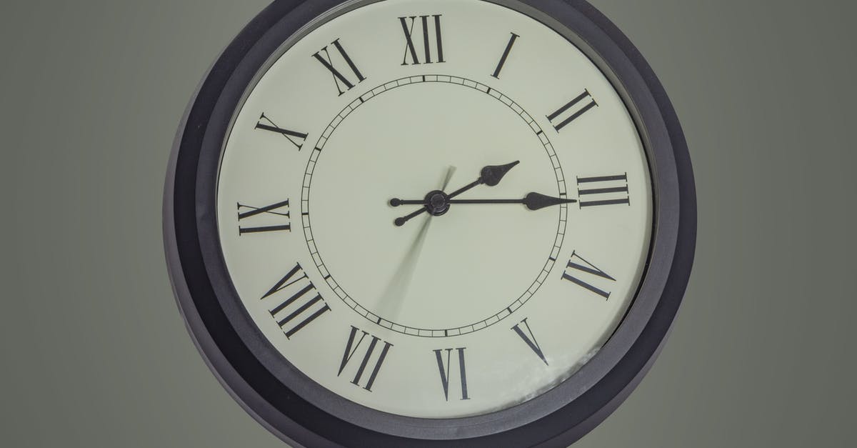 Pressure cooker delay timer use case - Round black mechanical clock with Roman numerals hanging on gray wall Pressure cooker delay timer use case - Round black mechanical clock with Roman numerals hanging on gray wall
