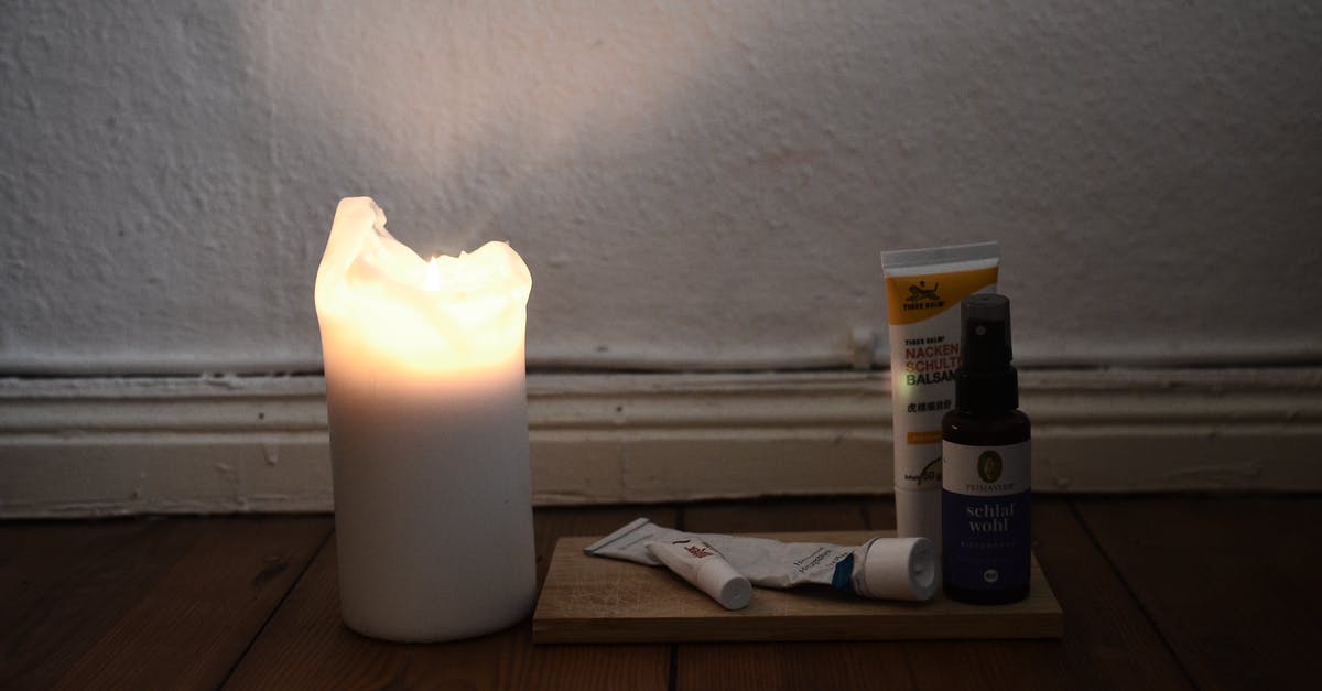 Preventing oil burn when searing steak - White burning candle placed on wooden floor with vials and tubes for skincare daily routine against white shabby wall in room at low light Preventing oil burn when searing steak - White burning candle placed on wooden floor with vials and tubes for skincare daily routine against white shabby wall in room at low light