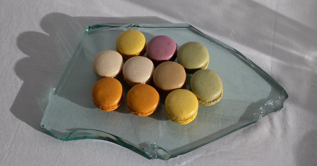 Preventing white sugar from clumping in the canister - From above of broken piece of glass on white fabric with arrangement of delicious macaroons on top Preventing white sugar from clumping in the canister - From above of broken piece of glass on white fabric with arrangement of delicious macaroons on top
