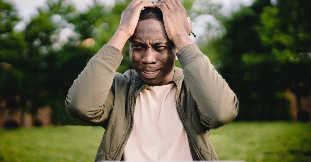 Problems using my black garlic fermenter - Disappointed black man holding head thinking about problem in front of laptop in park Problems using my black garlic fermenter - Disappointed black man holding head thinking about problem in front of laptop in park