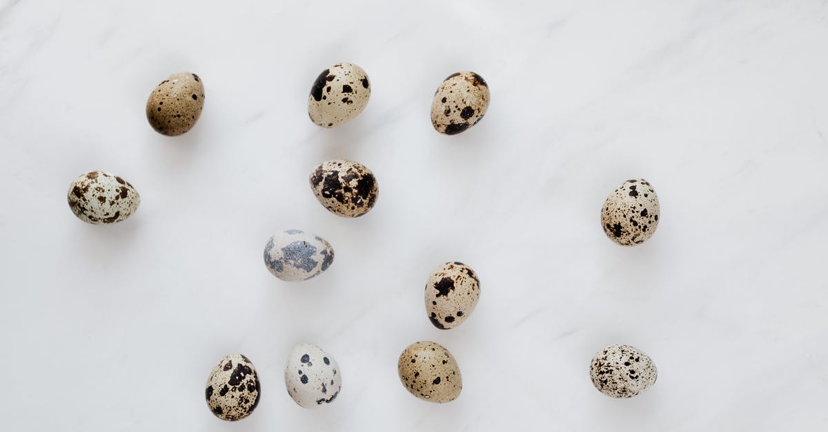 Quail dries out when cooked - Top view of natural quail eggs placed chaotically on white table during cooking process in kitchen Quail dries out when cooked - Top view of natural quail eggs placed chaotically on white table during cooking process in kitchen