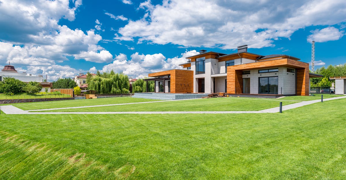 Quick flavour for fresh popcorn - Exterior of modern residential house with wooden walls and green grass growing in yard against blue sky with white clouds Quick flavour for fresh popcorn - Exterior of modern residential house with wooden walls and green grass growing in yard against blue sky with white clouds