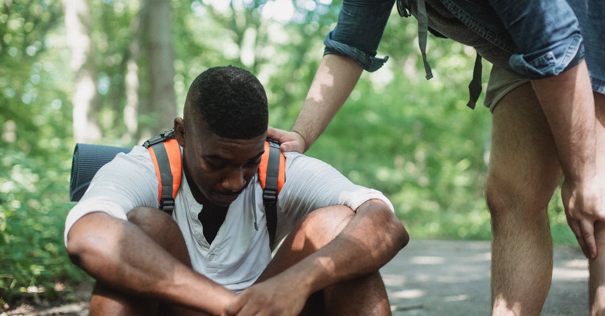 Quick pressure release vs natural pressure release - Unhappy black hiker sitting on ground in forest Quick pressure release vs natural pressure release - Unhappy black hiker sitting on ground in forest