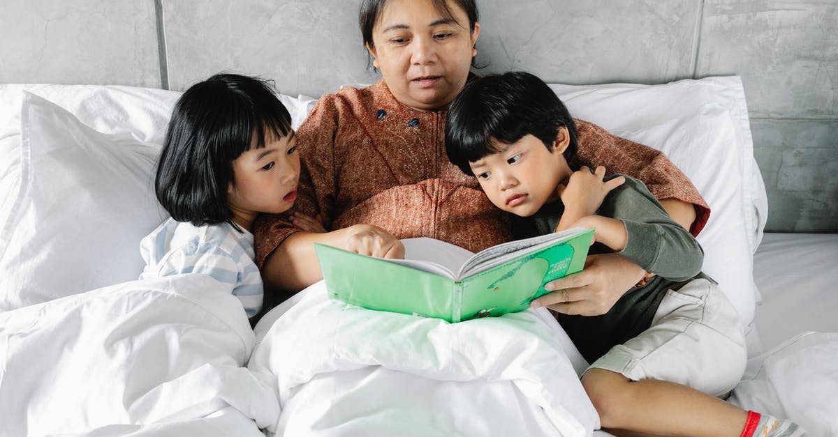 Recipes to calm down my kimchi [closed] - From above of Asian grandmother lying with little daughter and son during bed time and reading book