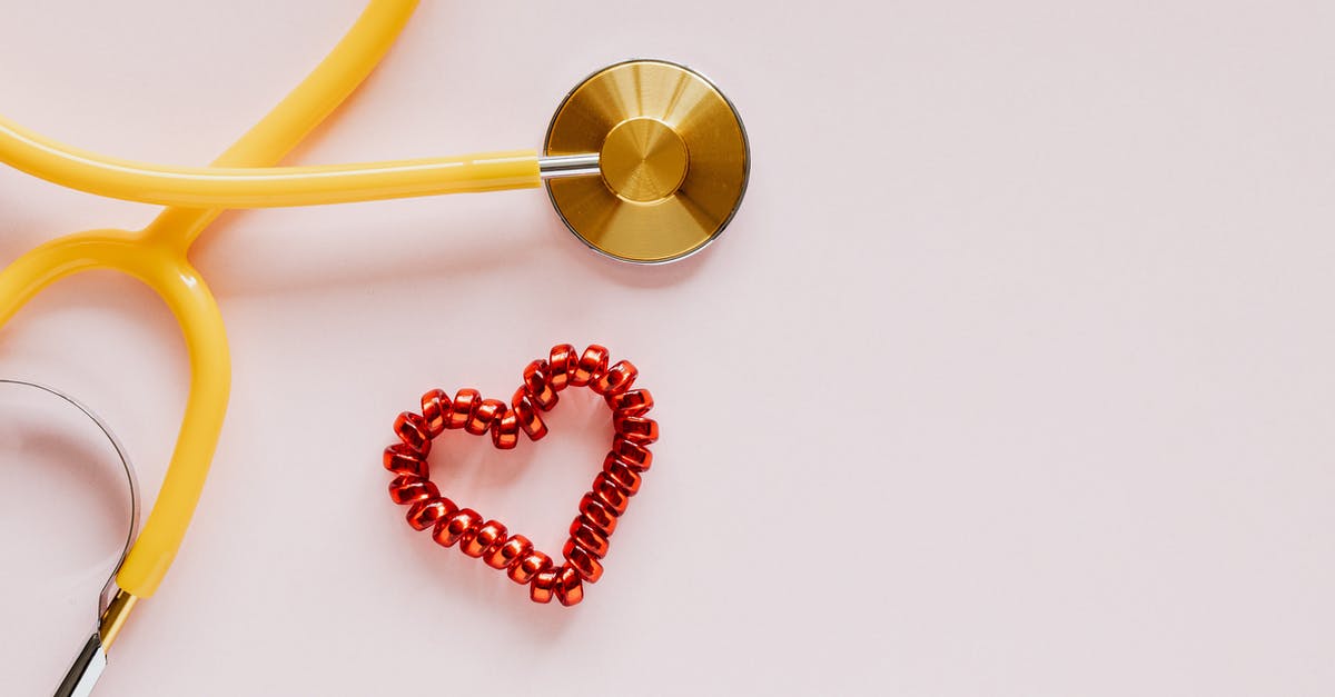 Red ptitim (pearl couscous)? - From above of yellow stethoscope near small red bead heart made for San Valentines Day on pale pink surface Red ptitim (pearl couscous)? - From above of yellow stethoscope near small red bead heart made for San Valentines Day on pale pink surface