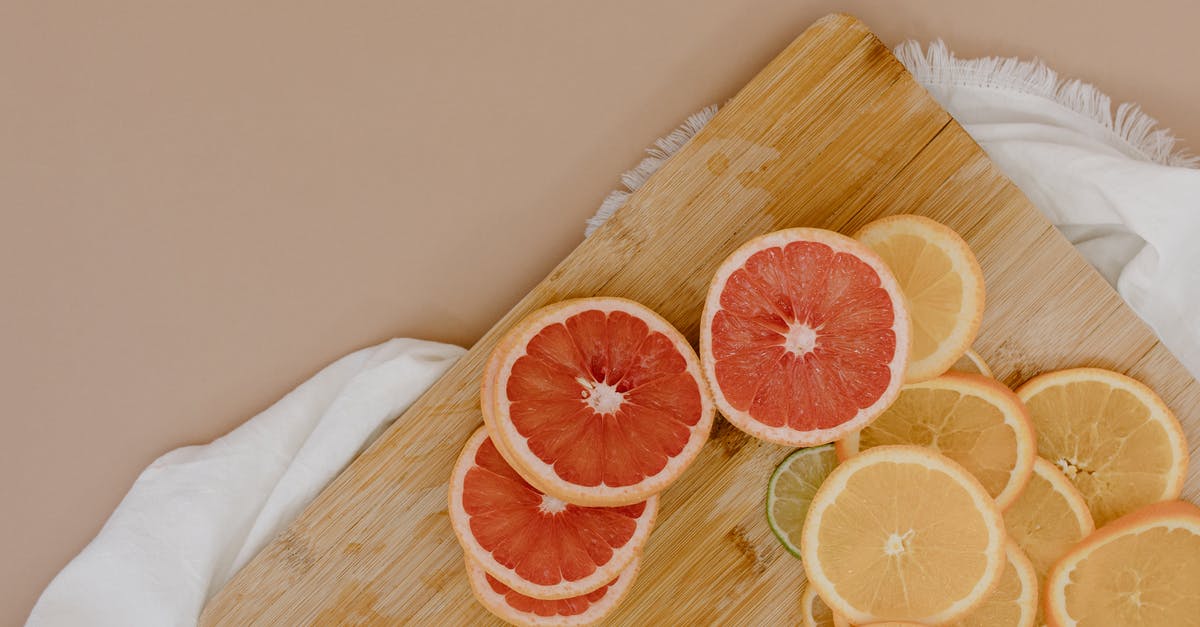 Red sweet and sour cabbage...drain or not? - Top view of wooden cutting board with sliced oranges and red grapefruits near green limes and yellow lemons on white textile on beige surface in light studio Red sweet and sour cabbage...drain or not? - Top view of wooden cutting board with sliced oranges and red grapefruits near green limes and yellow lemons on white textile on beige surface in light studio