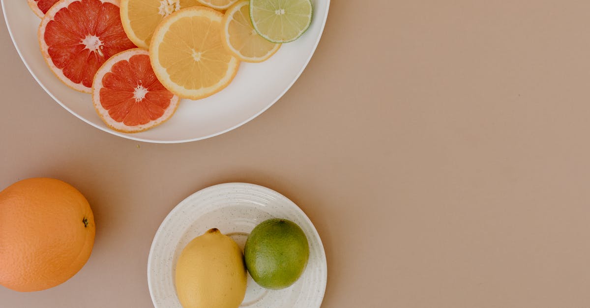 Red sweet and sour cabbage...drain or not? - Top view of sliced red grapefruits with oranges near yellow lemons and green limes on plates on beige surface in light place Red sweet and sour cabbage...drain or not? - Top view of sliced red grapefruits with oranges near yellow lemons and green limes on plates on beige surface in light place