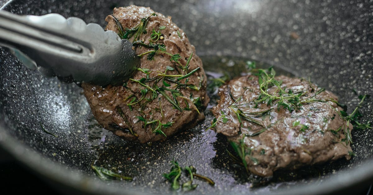 Reduce heat of mustard condiment - Juicy cutlets topped with aromatic rosemary frying in hot pan with metal tongs during cooking process in kitchen while preparing for lunch Reduce heat of mustard condiment - Juicy cutlets topped with aromatic rosemary frying in hot pan with metal tongs during cooking process in kitchen while preparing for lunch