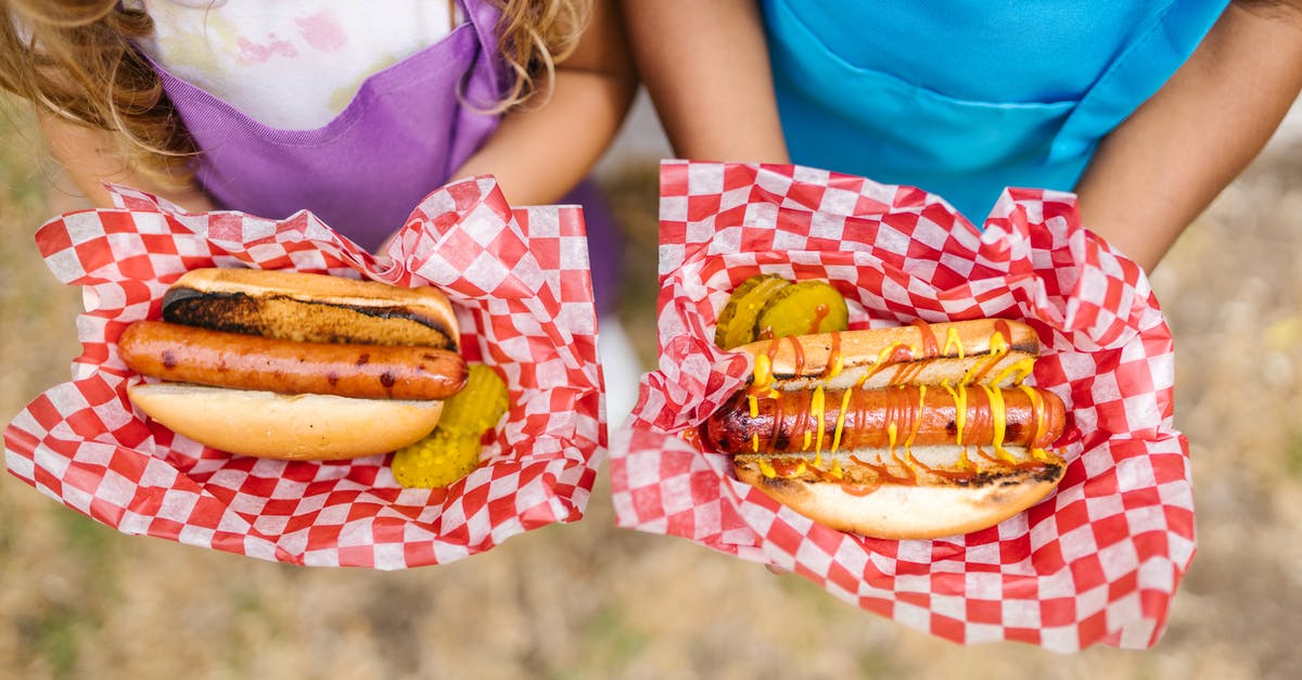 Reduce heat of mustard condiment - Woman in Teal Tank Top Holding Burger Reduce heat of mustard condiment - Woman in Teal Tank Top Holding Burger