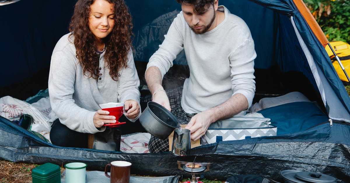 Regulating Gas Flow to a Cooktop - Crop couple of travelers preparing coffee in tent Regulating Gas Flow to a Cooktop - Crop couple of travelers preparing coffee in tent
