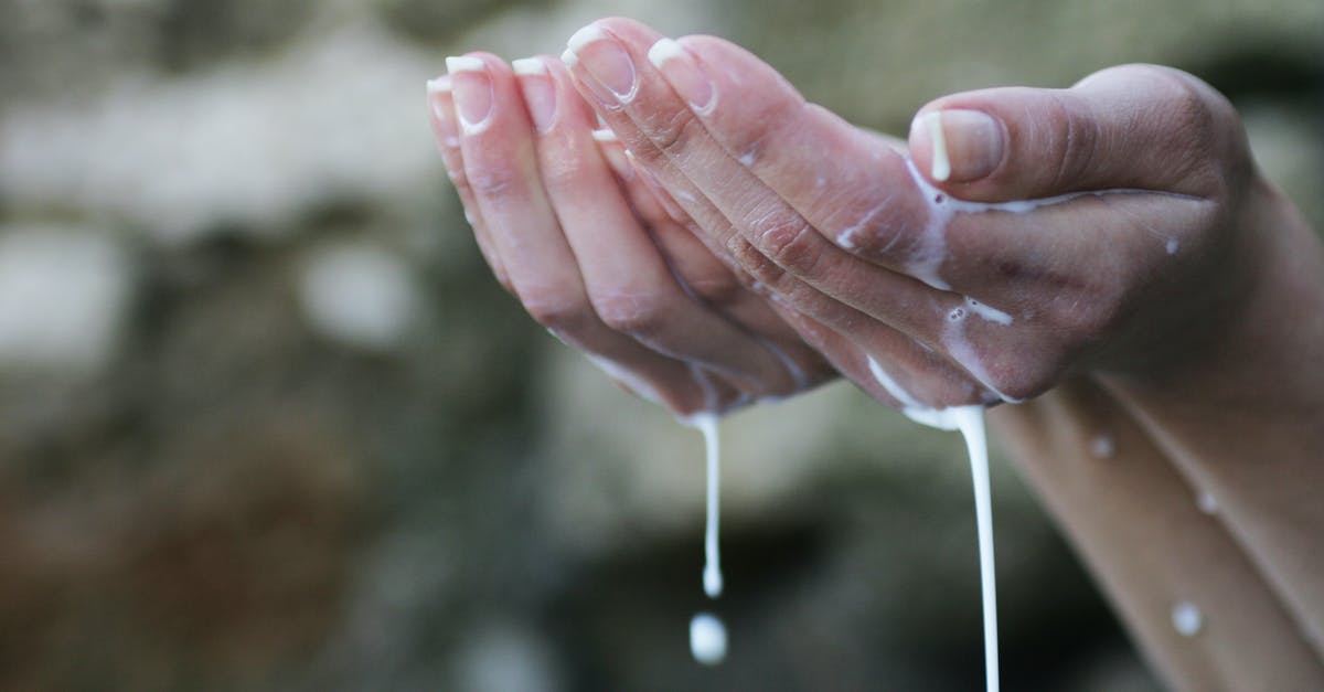 re-hydrate dried and salted cod with water and milk - Person's Hands Covered in White Liquid re-hydrate dried and salted cod with water and milk - Person's Hands Covered in White Liquid