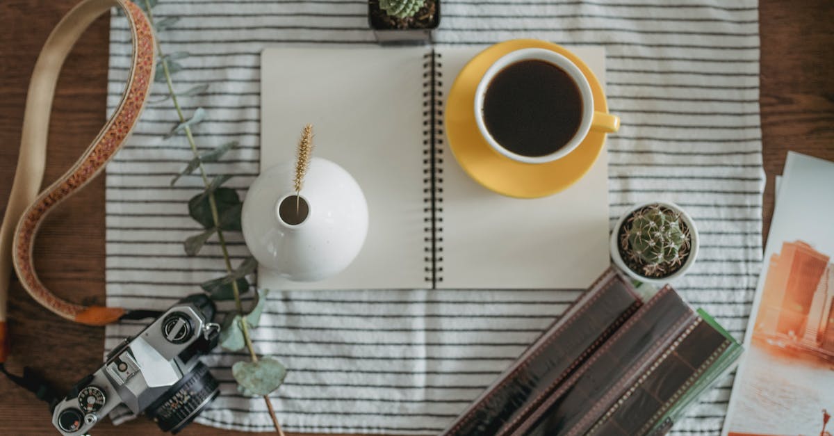 Remove tannins from tea without removing caffeine - From above of cup of coffee and white vase placed near vintage photo camera and potted plants on wooden table in daytime Remove tannins from tea without removing caffeine - From above of cup of coffee and white vase placed near vintage photo camera and potted plants on wooden table in daytime