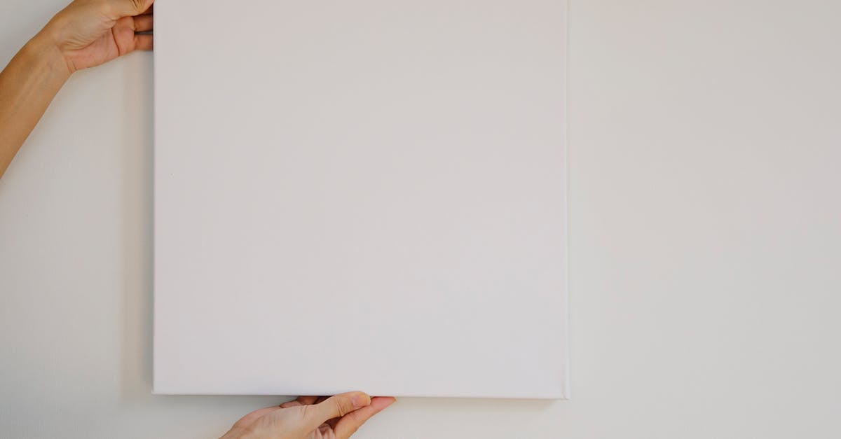 Removing macaron paper template under silicone mat - Unrecognizable female demonstrating empty poster of square shape during advertisement campaign against gray wall Removing macaron paper template under silicone mat - Unrecognizable female demonstrating empty poster of square shape during advertisement campaign against gray wall