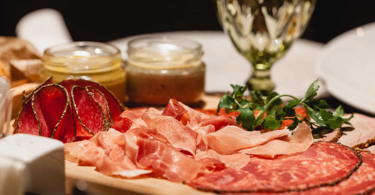 Replacing red wine by vinegar to do a beef salami - Delicious meat and salami with sauce and wineglass on table Replacing red wine by vinegar to do a beef salami - Delicious meat and salami with sauce and wineglass on table