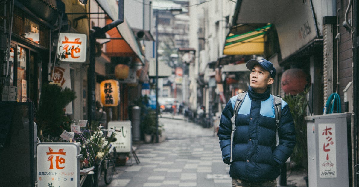 restaurants terms - Man Walking on Grey Concrete Alley Surrounded by Buildings restaurants terms - Man Walking on Grey Concrete Alley Surrounded by Buildings