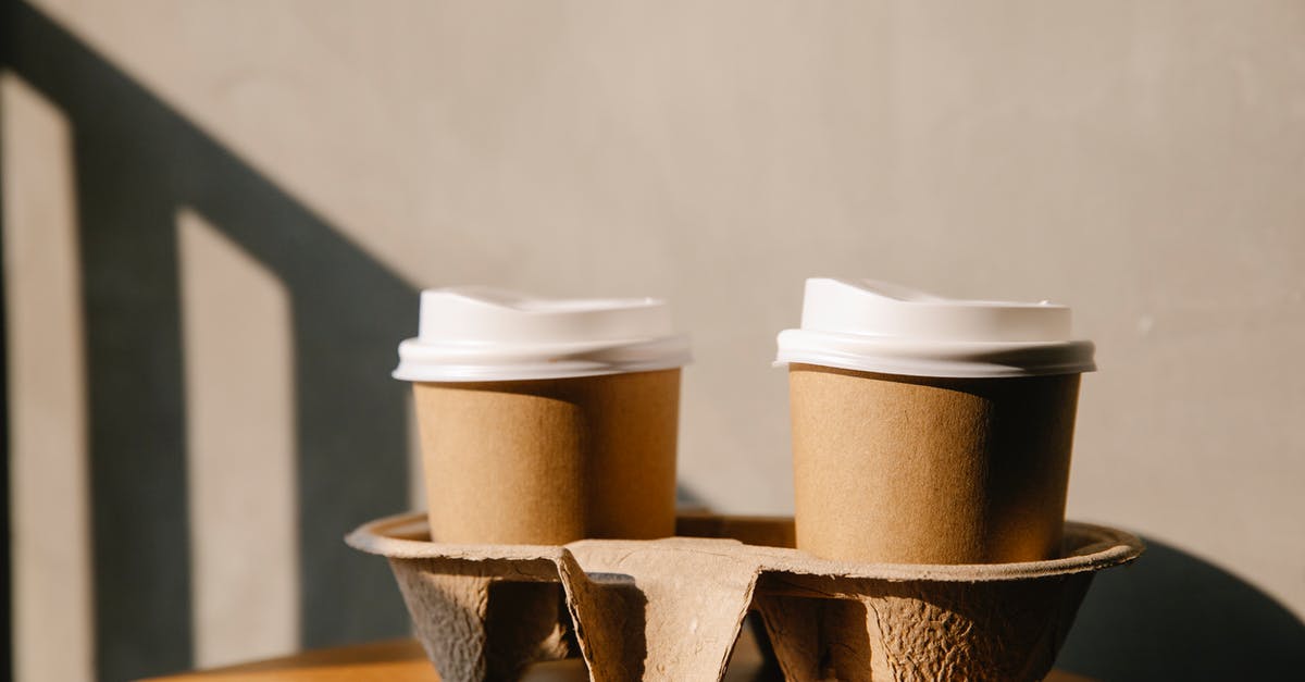 Reusing coffee grounds - Cardboard cups on holder tray on table Reusing coffee grounds - Cardboard cups on holder tray on table