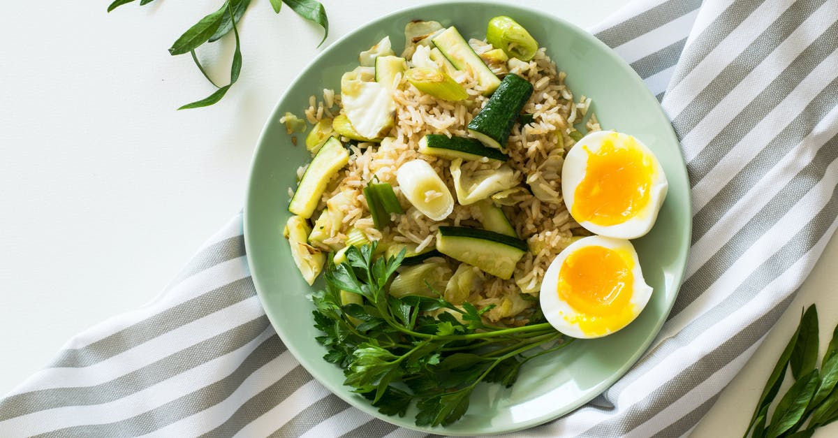 Rice with worm and possibly their eggs - Fried Rice With Poached Egg, Zucchini, And Celery on Round Green Ceramic Plate Rice with worm and possibly their eggs - Fried Rice With Poached Egg, Zucchini, And Celery on Round Green Ceramic Plate