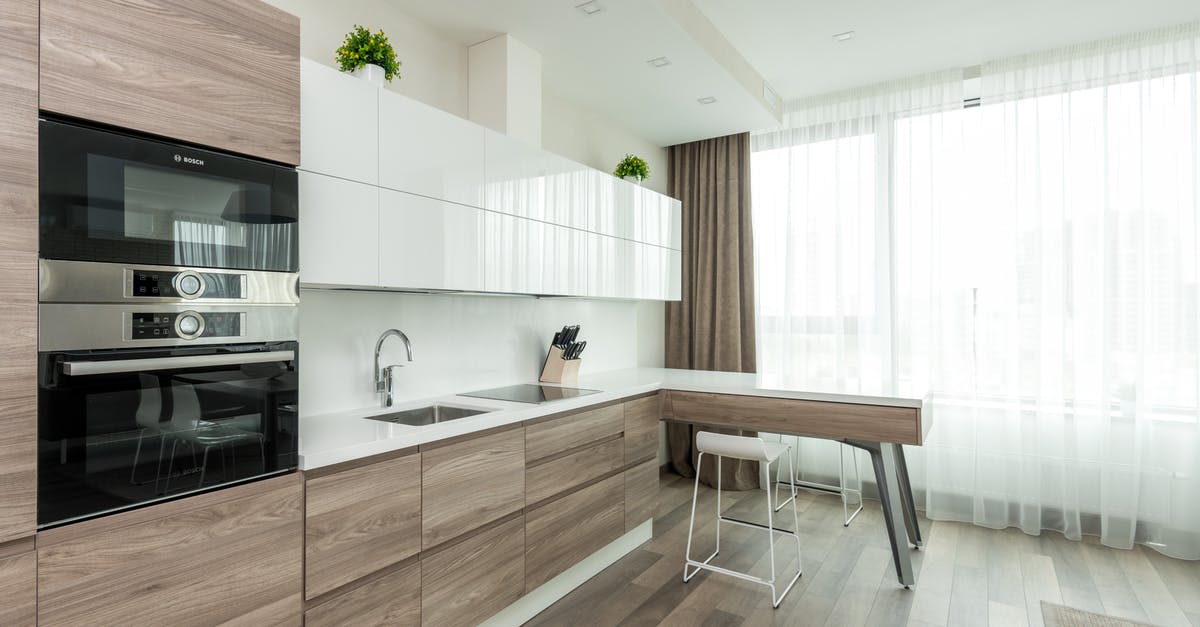 Rigging equipment for steaming large amounts at once - Interior of modern light kitchen with white and wooden cabinets and contemporary appliances in apartment Rigging equipment for steaming large amounts at once - Interior of modern light kitchen with white and wooden cabinets and contemporary appliances in apartment