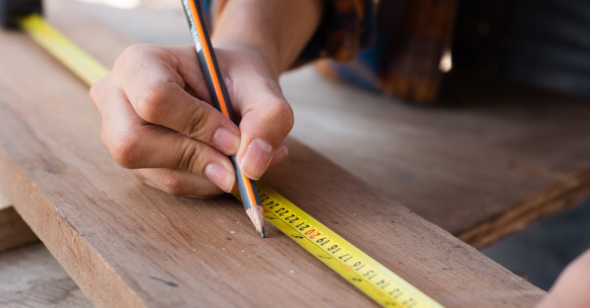 Royal icing - how important is accurate measuring? - Woman Measuring with Yellow Pencil on Board Royal icing - how important is accurate measuring? - Woman Measuring with Yellow Pencil on Board