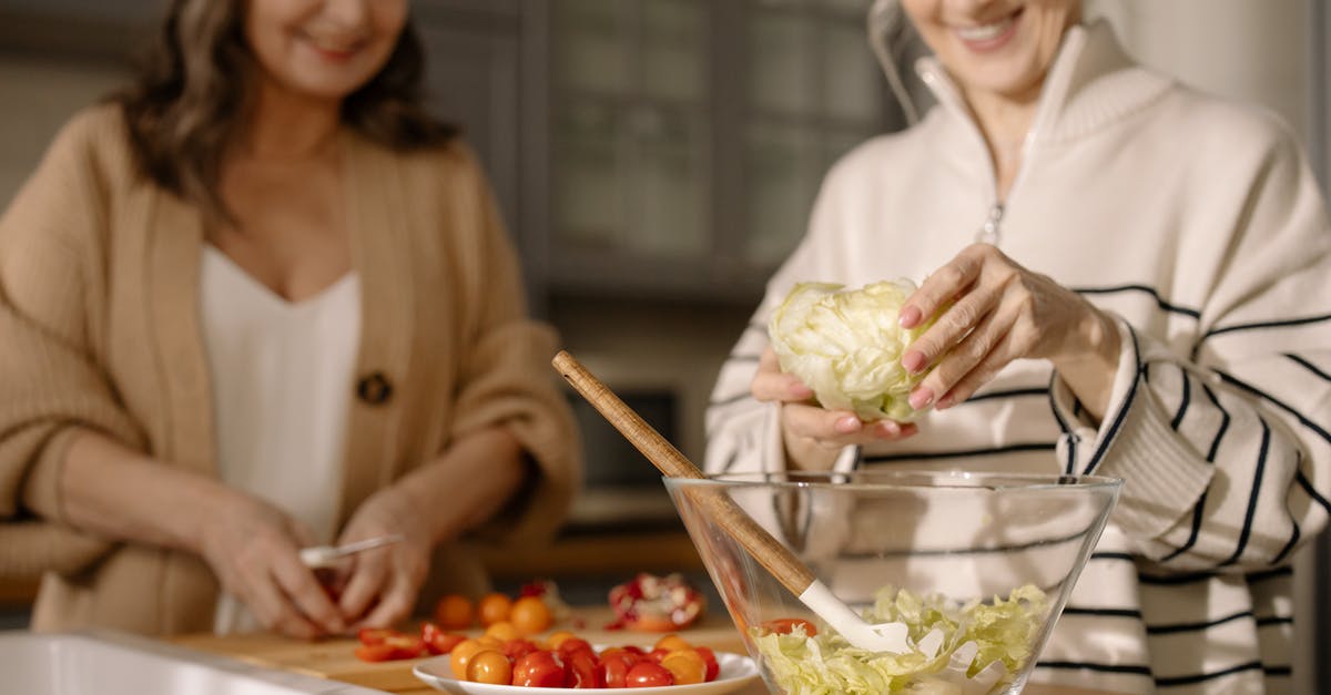 Safe and efficient way to keep hands clean while preparing food [duplicate] - An Elderly Women Preparing Fresh Salad in the Kitchen