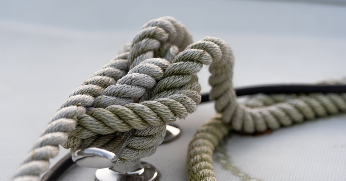 safety of "tin" cans dented in shipping - Closeup of strong mooring rope tied around steel anchor with nautical knot on modern yacht safety of "tin" cans dented in shipping - Closeup of strong mooring rope tied around steel anchor with nautical knot on modern yacht