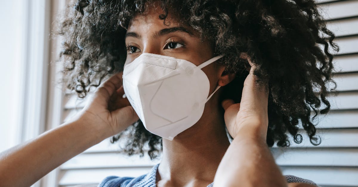 Safety of white canned beans - Black woman putting on respirator Safety of white canned beans - Black woman putting on respirator