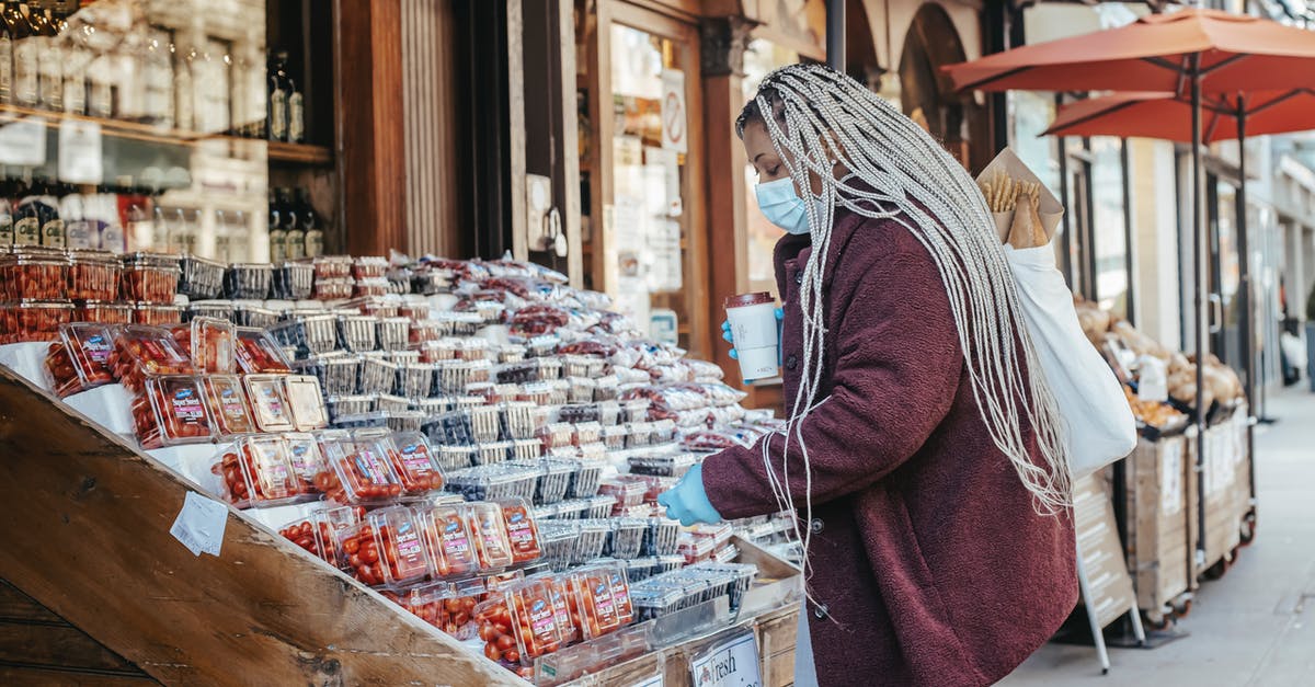 Safety with vacuum packed food [duplicate] - Black woman buying fruits in street stall