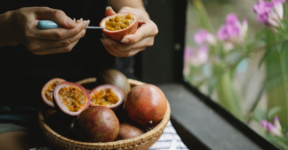 Salad ingredients: how to pick them at the market? - Unrecognizable woman picking up juicy pulp of passion fruit while cooking healthy lunch Salad ingredients: how to pick them at the market? - Unrecognizable woman picking up juicy pulp of passion fruit while cooking healthy lunch