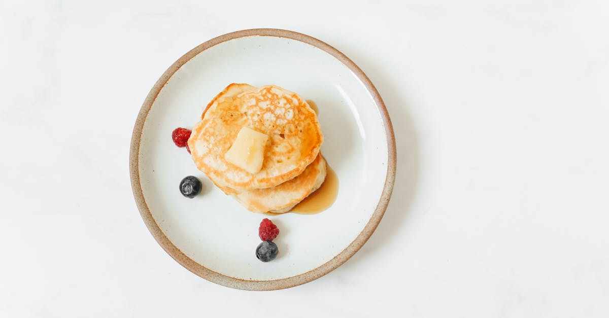 Salted butter in toffee - Pancakes With Red and Black Berries on White Ceramic Plate Salted butter in toffee - Pancakes With Red and Black Berries on White Ceramic Plate