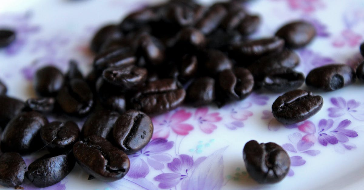 Samovar Tea: Let it brew the whole day? - Closeup heap of aromatic roasted coffee beans placed on tablecloth with floral ornament Samovar Tea: Let it brew the whole day? - Closeup heap of aromatic roasted coffee beans placed on tablecloth with floral ornament