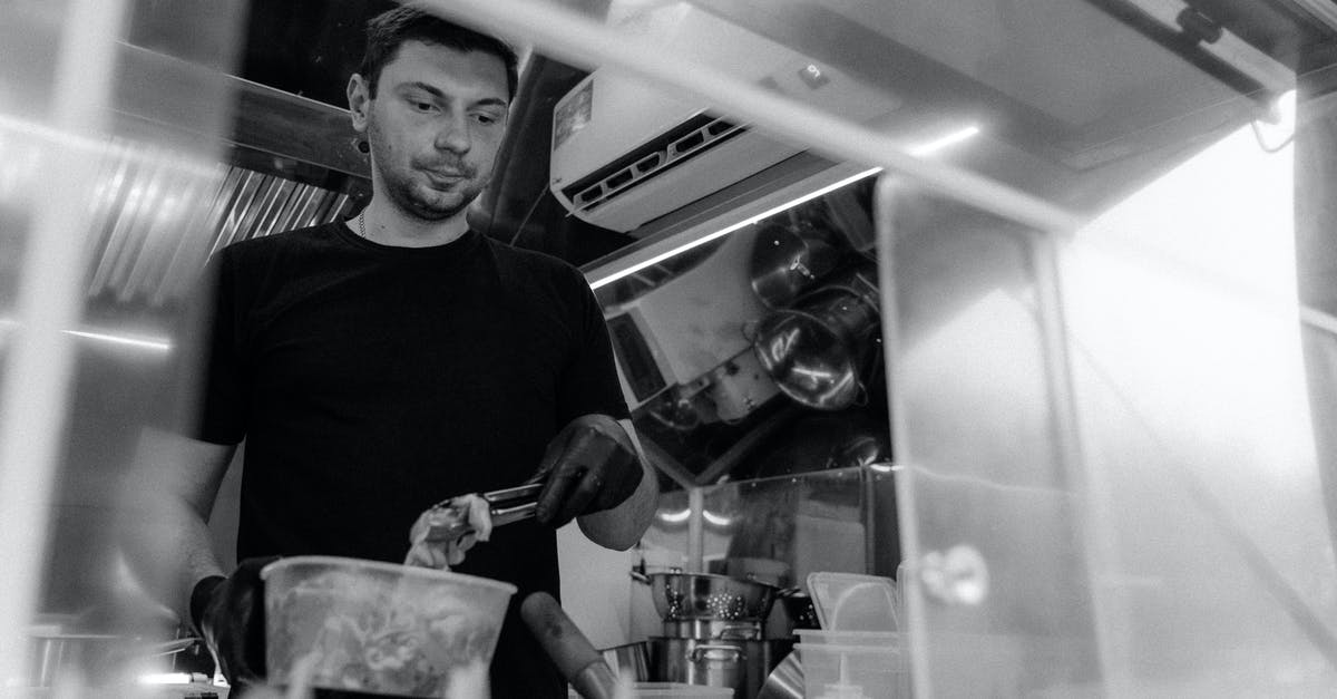 Sanitising Black chef "whites" - A Grayscale of a Man Wearing a Black Shirt Working in a Kitchen Sanitising Black chef "whites" - A Grayscale of a Man Wearing a Black Shirt Working in a Kitchen