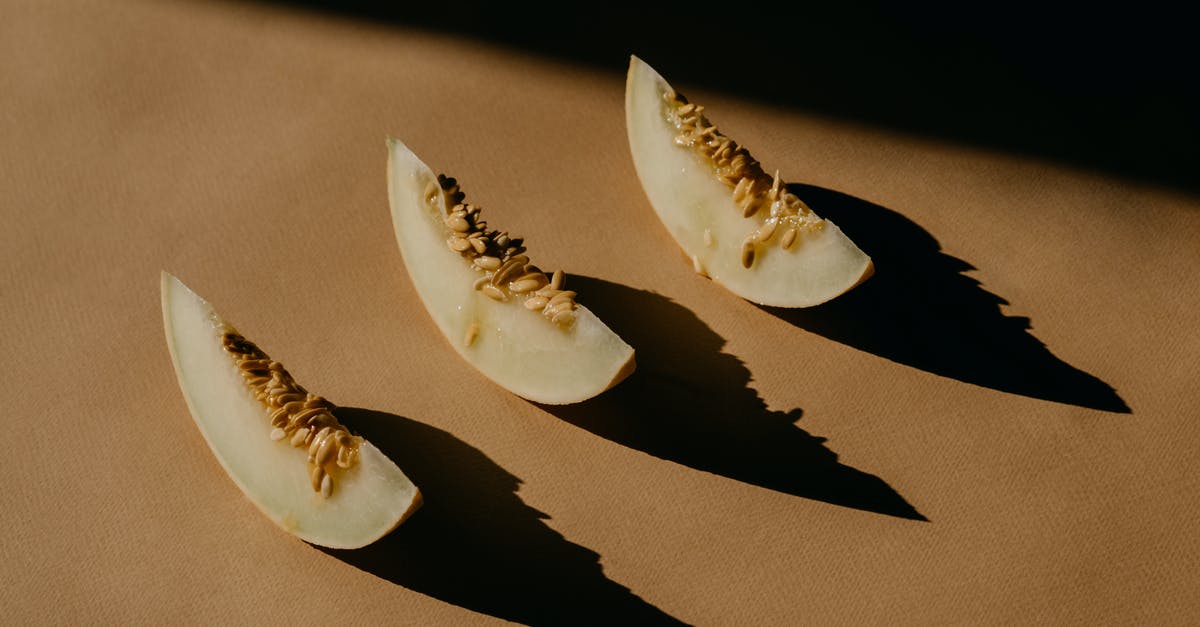 Santa Claus melon seeds - Melon Slices on a Brown Surface Santa Claus melon seeds - Melon Slices on a Brown Surface
