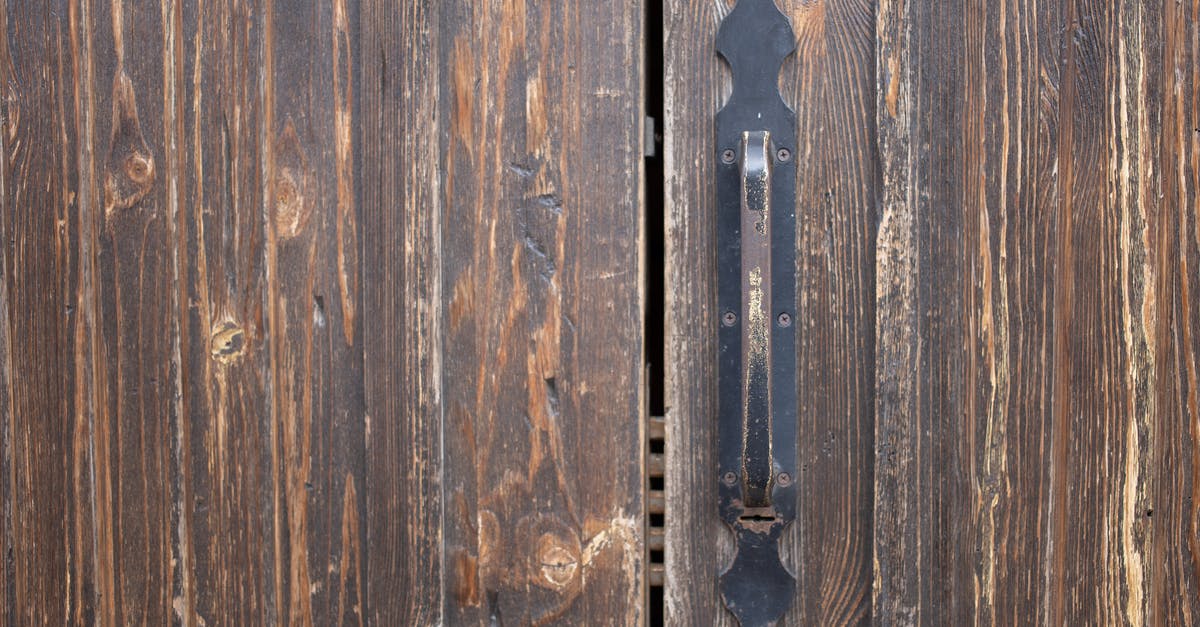 Scratched coating in old ice-cream maker: is it safe? - Closeup of weathered old rusty brown locked wooden door with cracks on surface with aged metal handle Scratched coating in old ice-cream maker: is it safe? - Closeup of weathered old rusty brown locked wooden door with cracks on surface with aged metal handle